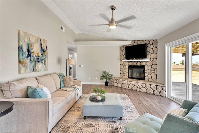 11969 Pinon Ave, Hesperia, CA 92345 - living room with ceiling fan, lofted ceiling, wood finished floors, a fireplace, and a textured ceiling