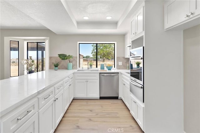 11969 Pinon Ave, Hesperia, CA 92345 - kitchen featuring stainless steel appliances, a warming drawer, a raised ceiling, white cabinets, and a textured ceiling