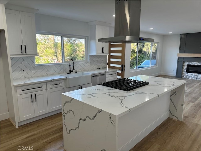 632 Truly Unit 634, Vista, CA 92084 - kitchen featuring island exhaust hood, stovetop, light wood-style floors, a kitchen island, and stainless steel dishwasher