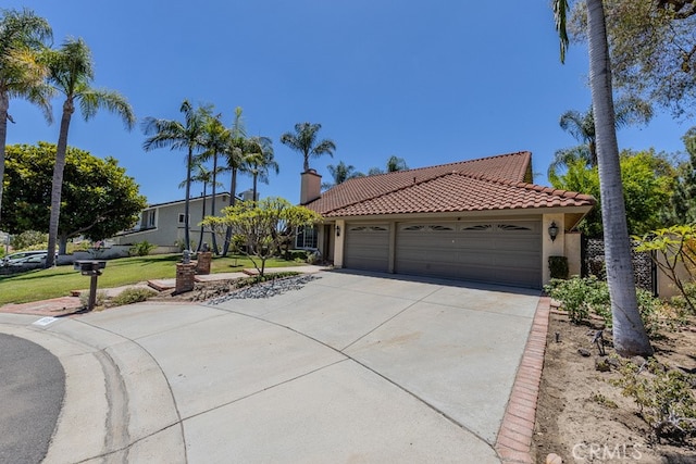 5035 Via Donaldo, Yorba Linda, CA 92886 - view of front of house with concrete driveway, an attached garage, stucco siding, a tiled roof, and a chimney