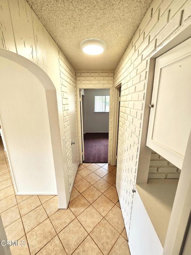 2573 Tiller Ave, Port Hueneme, CA 93041 - hallway with light tile patterned floors, a textured ceiling, and brick wall