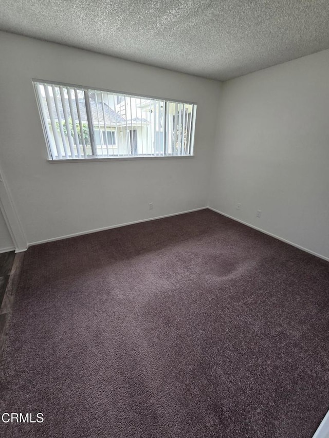 2573 Tiller Ave, Port Hueneme, CA 93041 - unfurnished room featuring plenty of natural light, a textured ceiling, and dark colored carpet