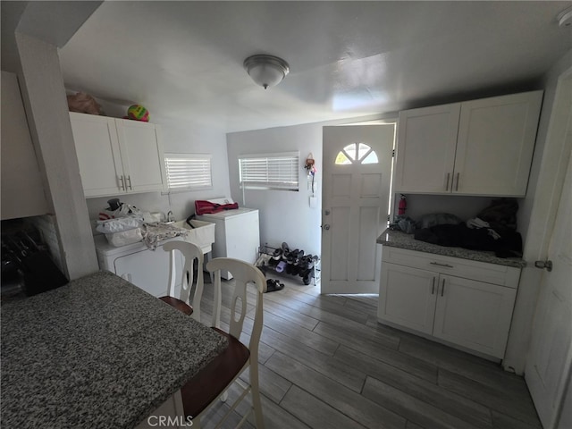 3424 E Cesar E Chavez Ave, Los Angeles, CA 90063 - kitchen with white cabinets, light wood-type flooring, stone countertops, and washer and clothes dryer