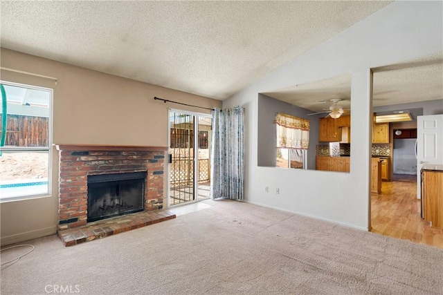 13491 Solitude Cir, Victorville, CA 92392 - unfurnished living room with a textured ceiling, a fireplace, light colored carpet, plenty of natural light, and a ceiling fan