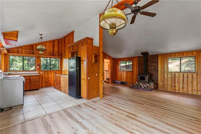 22490 Rockwell Rd, Cedarpines Park, CA 92322 - kitchen featuring lofted ceiling, stove, freestanding refrigerator, wood walls, and a wood stove