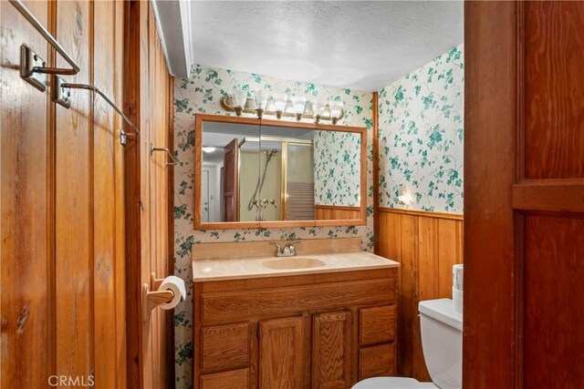 22490 Rockwell Rd, Cedarpines Park, CA 92322 - bathroom with wallpapered walls, a textured ceiling, a wainscoted wall, vanity, and a shower