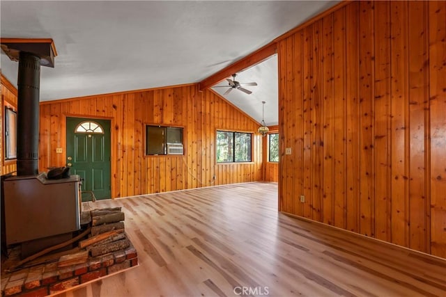 22490 Rockwell Rd, Cedarpines Park, CA 92322 - unfurnished living room with wood finished floors, ceiling fan, a wood stove, wooden walls, and vaulted ceiling