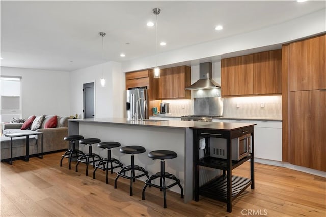 1029 White Knoll Dr, Los Angeles, CA 90012 - kitchen with wall chimney exhaust hood, modern cabinets, brown cabinets, a breakfast bar area, and appliances with stainless steel finishes