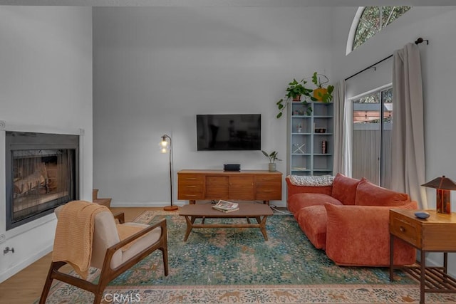 8939 Gallatin Rd Unit 116, Pico Rivera, CA 90660 - living room featuring a towering ceiling, a fireplace, and wood finished floors