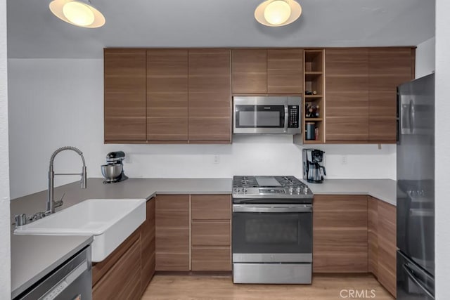 8939 Gallatin Rd Unit 116, Pico Rivera, CA 90660 - kitchen with stainless steel appliances, brown cabinetry, and modern cabinets