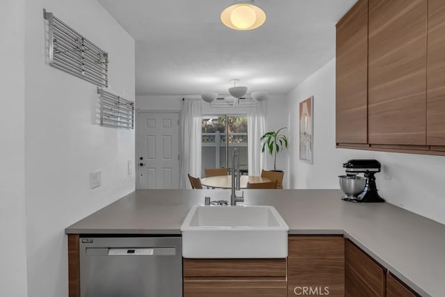 8939 Gallatin Rd Unit 116, Pico Rivera, CA 90660 - kitchen with stainless steel dishwasher, brown cabinetry, a chandelier, a peninsula, and light countertops