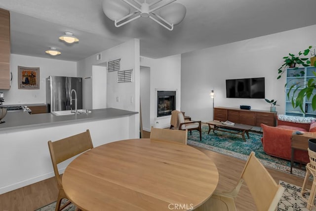 8939 Gallatin Rd Unit 116, Pico Rivera, CA 90660 - dining area with wood finished floors, a fireplace, and a ceiling fan