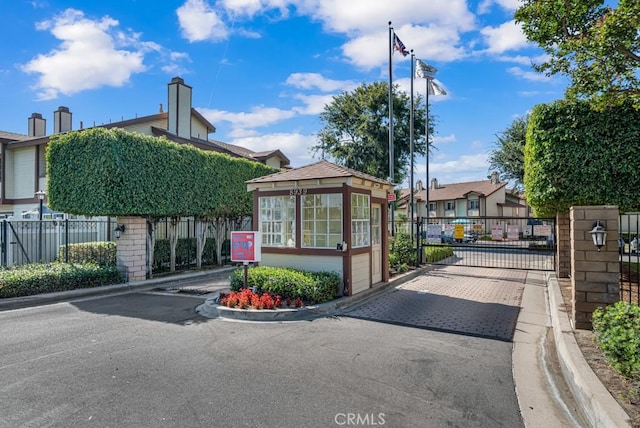 8939 Gallatin Rd Unit 116, Pico Rivera, CA 90660 - view of asphalt road featuring a gate, curbs, street lighting, and a gated entry