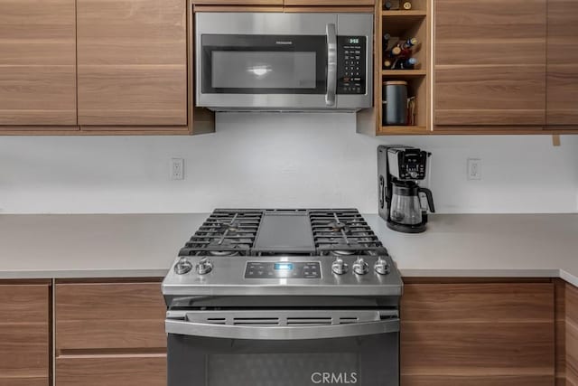 8939 Gallatin Rd Unit 116, Pico Rivera, CA 90660 - kitchen with stainless steel appliances, brown cabinetry, and modern cabinets