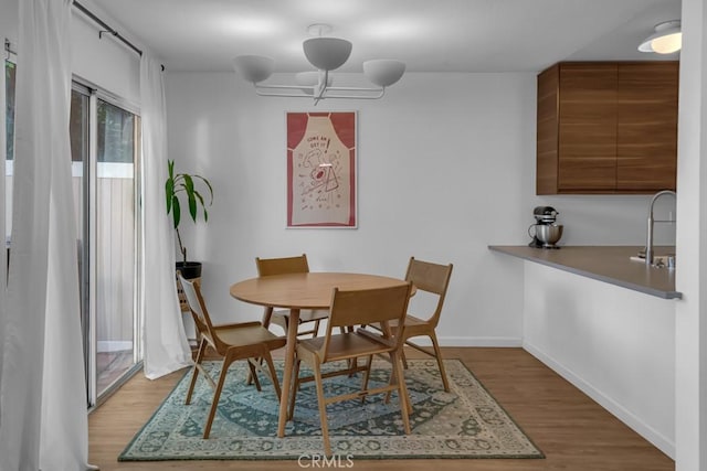 8939 Gallatin Rd Unit 116, Pico Rivera, CA 90660 - dining space featuring wood finished floors and a chandelier
