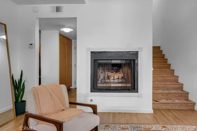 8939 Gallatin Rd Unit 116, Pico Rivera, CA 90660 - sitting room with light wood-style floors, a fireplace, and stairs