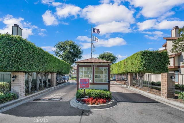 8939 Gallatin Rd Unit 116, Pico Rivera, CA 90660 - view of asphalt road with a gate, curbs, and a gated entry