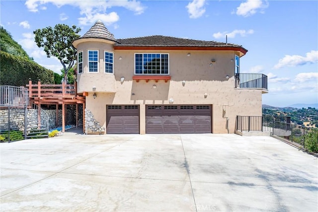 918 Reposado Dr, La Habra Heights, CA 90631 - rear view of house featuring an attached garage, stucco siding, concrete driveway, stairs, and a balcony