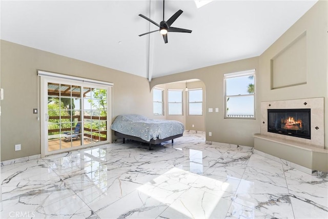 918 Reposado Dr, La Habra Heights, CA 90631 - bedroom with access to exterior, marble tiled floors, a glass covered fireplace, arched walkways, and ceiling fan