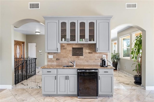 918 Reposado Dr, La Habra Heights, CA 90631 - kitchen featuring arched walkways, decorative backsplash, and gray cabinetry