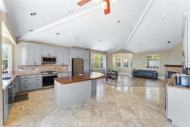 918 Reposado Dr, La Habra Heights, CA 90631 - kitchen featuring vaulted ceiling, open floor plan, stainless steel appliances, butcher block countertops, and tasteful backsplash