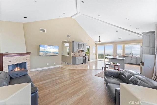 918 Reposado Dr, La Habra Heights, CA 90631 - living room featuring high vaulted ceiling, light wood-style flooring, ceiling fan, beam ceiling, and a fireplace