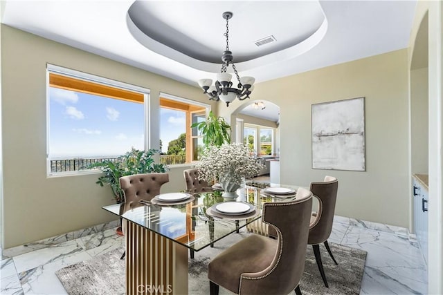 918 Reposado Dr, La Habra Heights, CA 90631 - dining space with a chandelier, arched walkways, marble finish flooring, and a tray ceiling