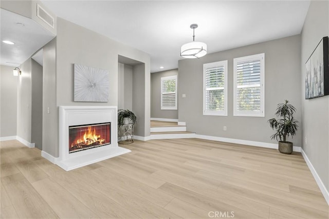 29 Hinterland Way, Ladera Ranch, CA 92694 - unfurnished living room with light wood-type flooring, a glass covered fireplace, and recessed lighting