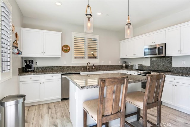 4989 River Ash Way, Fontana, CA 92336 - kitchen with appliances with stainless steel finishes, light wood finished floors, white cabinets, and recessed lighting