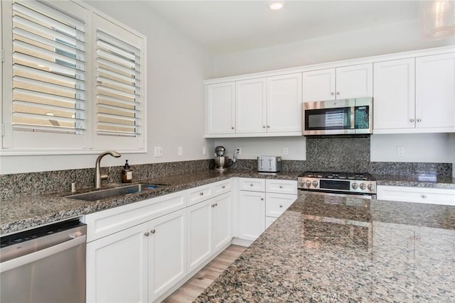 4989 River Ash Way, Fontana, CA 92336 - kitchen featuring stainless steel appliances, white cabinets, dark stone counters, light wood-style flooring, and recessed lighting