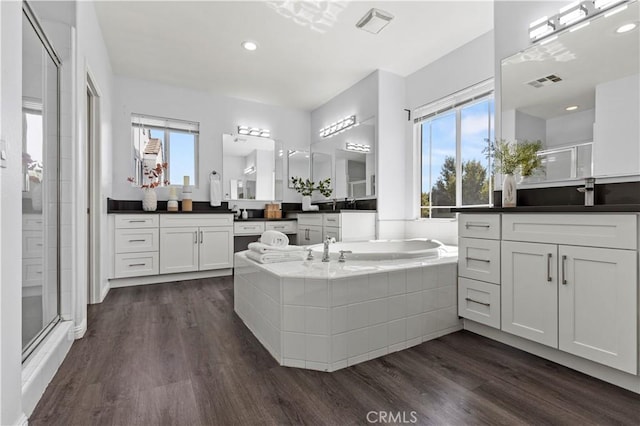 6219 S Kingsmill Ct, Fontana, CA 92336 - full bathroom featuring a stall shower, two vanities, a bath, and wood finished floors