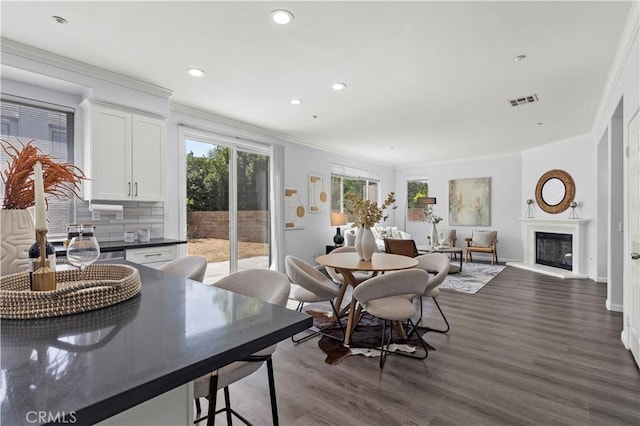 6219 S Kingsmill Ct, Fontana, CA 92336 - dining room with ornamental molding, dark wood finished floors, recessed lighting, and a glass covered fireplace