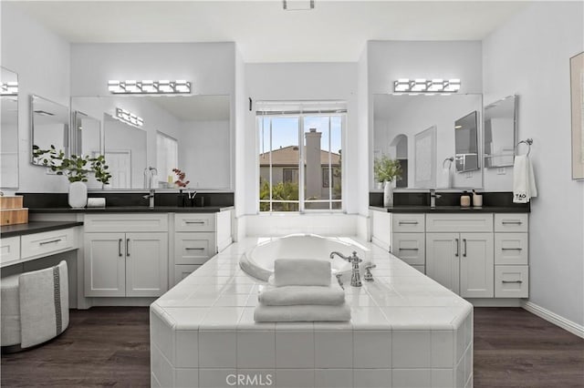 6219 S Kingsmill Ct, Fontana, CA 92336 - bathroom featuring two vanities, wood finished floors, and a bath
