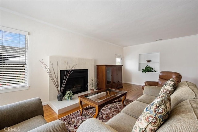 215 S Mason St, Arroyo Grande, CA 93420 - living room featuring healthy amount of natural light, wood finished floors, a fireplace with raised hearth, and crown molding