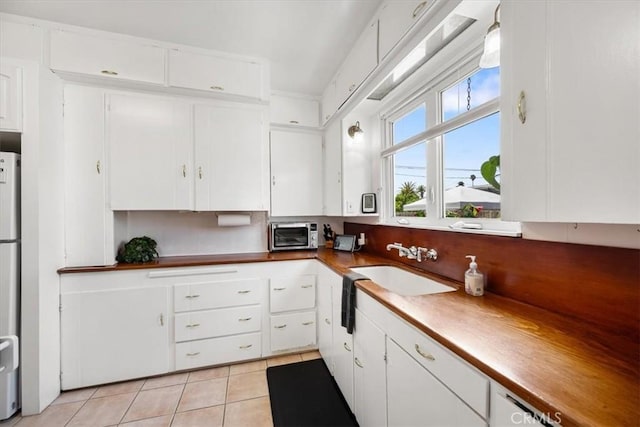 215 S Mason St, Arroyo Grande, CA 93420 - kitchen with light tile patterned floors and white cabinetry