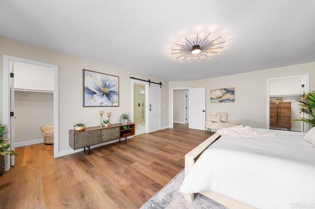 6270 Meadowcrest Dr, La Mesa, CA 91942 - bedroom featuring a barn door, a walk in closet, light wood-style floors, a closet, and ensuite bath