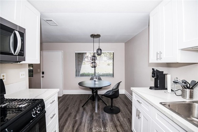 1000 Central Ave Unit 19, Riverside, CA 92507 - kitchen featuring stainless steel microwave, black gas range, dark wood-type flooring, and white cabinets
