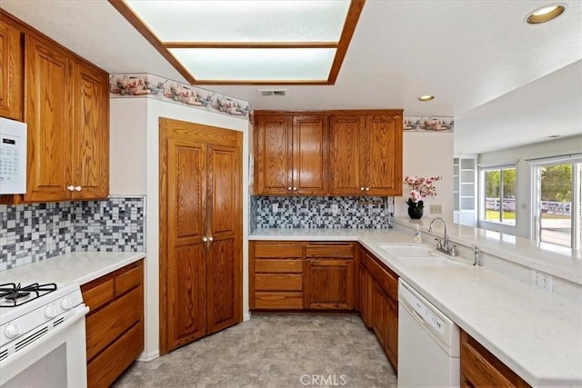 31655 Pio Pico Rd, Temecula, CA 92592 - kitchen with white appliances, brown cabinetry, light countertops, decorative backsplash, and recessed lighting