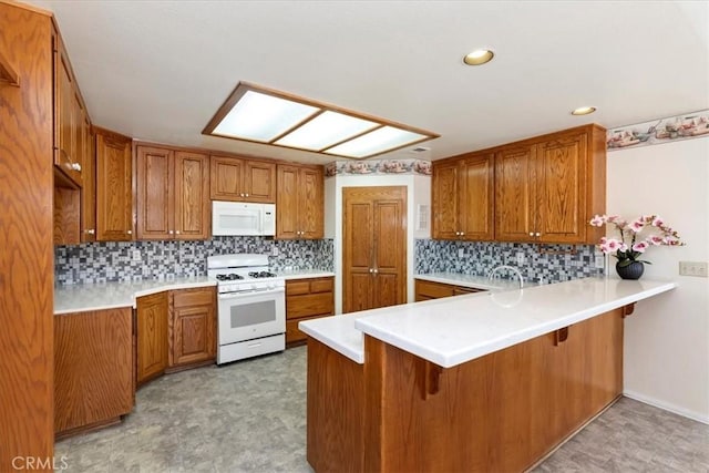 31655 Pio Pico Rd, Temecula, CA 92592 - kitchen featuring white appliances, brown cabinetry, a peninsula, a kitchen breakfast bar, and recessed lighting