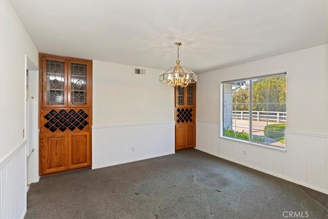 31655 Pio Pico Rd, Temecula, CA 92592 - unfurnished room featuring a wainscoted wall, a chandelier, and dark colored carpet