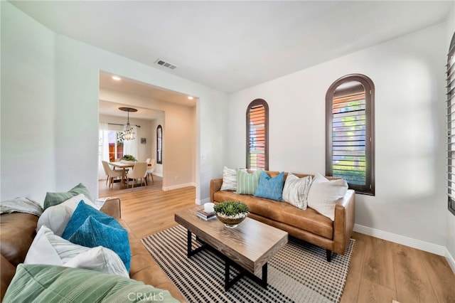 8 Caltrop Way, Ladera Ranch, CA 92694 - living room with light wood-style flooring, arched walkways, and a chandelier