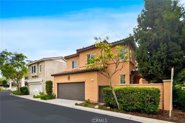 8 Caltrop Way, Ladera Ranch, CA 92694 - view of front of house featuring an attached garage, stucco siding, a tile roof, and driveway