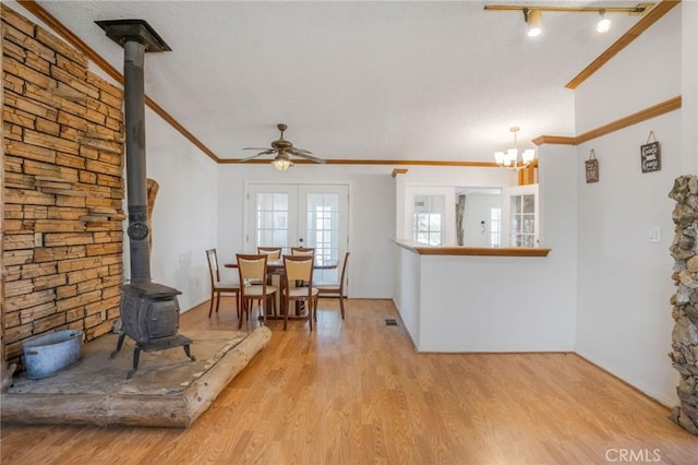 49750 Three Points Rd, Lancaster, CA 93536 - dining area featuring a wood stove, ornamental molding, light wood-style floors, a ceiling fan, and a chandelier