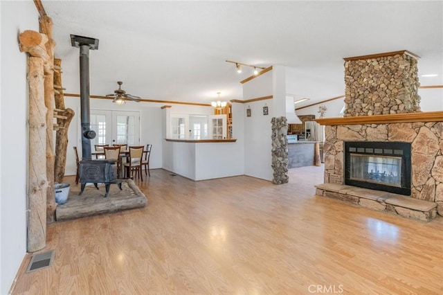 49750 Three Points Rd, Lancaster, CA 93536 - living area featuring a wood stove, a ceiling fan, wood finished floors, ornamental molding, and a fireplace
