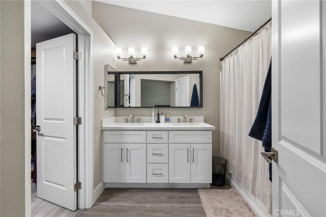 7550 Periwinkle Dr, Fontana, CA 92336 - full bathroom featuring wood finished floors and double vanity