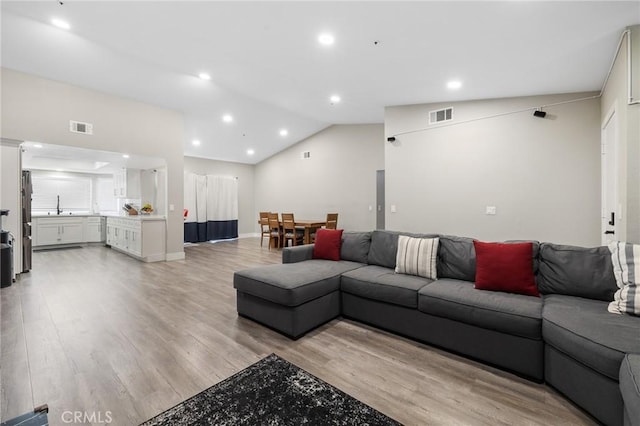 7550 Periwinkle Dr, Fontana, CA 92336 - living area with light wood-style flooring, vaulted ceiling, and recessed lighting