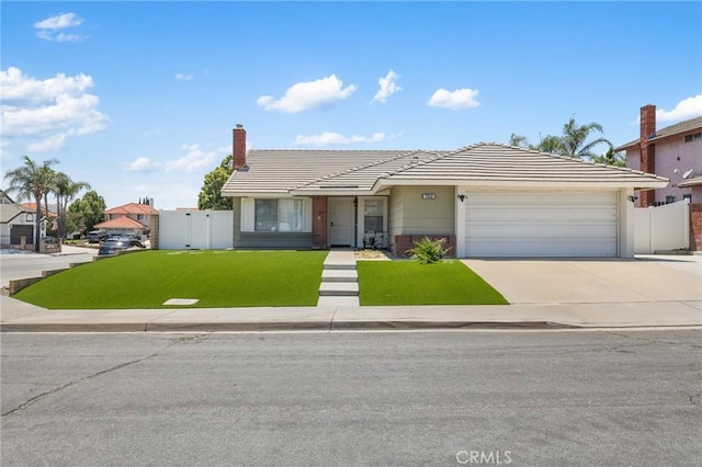 7550 Periwinkle Dr, Fontana, CA 92336 - view of front of home featuring a tile roof, an attached garage, driveway, and a gate