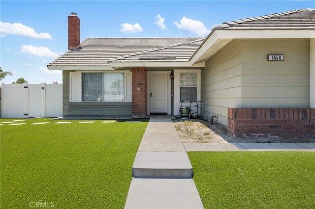 7550 Periwinkle Dr, Fontana, CA 92336 - doorway to property featuring a tile roof and a chimney