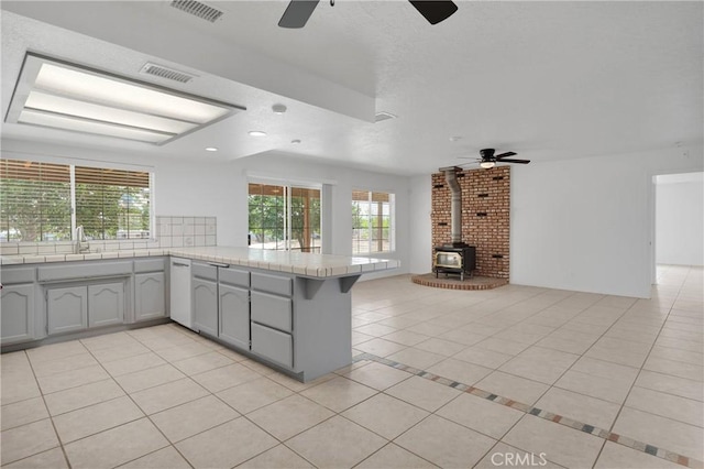 9191 White Rd, Phelan, CA 92371 - kitchen featuring a ceiling fan, a peninsula, plenty of natural light, a wood stove, and recessed lighting
