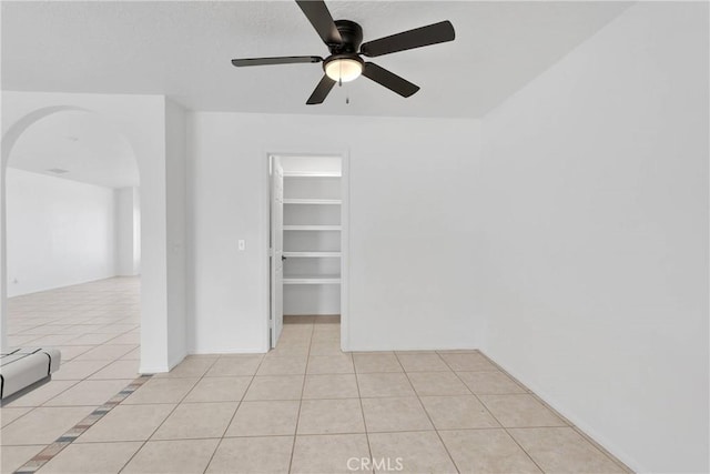 9191 White Rd, Phelan, CA 92371 - spare room featuring arched walkways, light tile patterned floors, and ceiling fan
